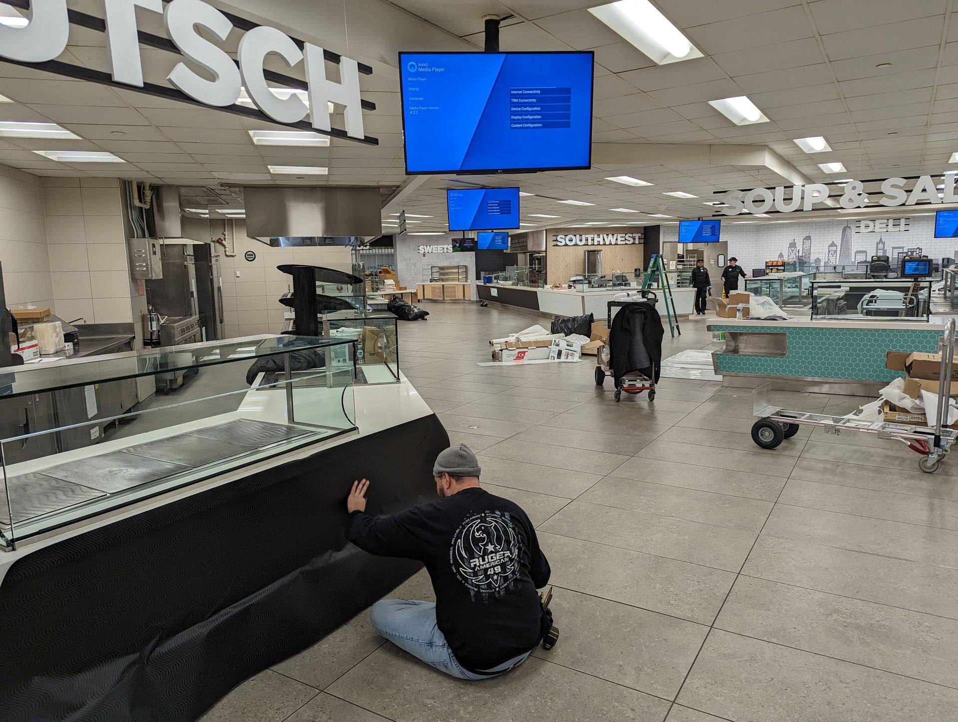 WAND digital displays being installed in a food hall with Media Player on screen